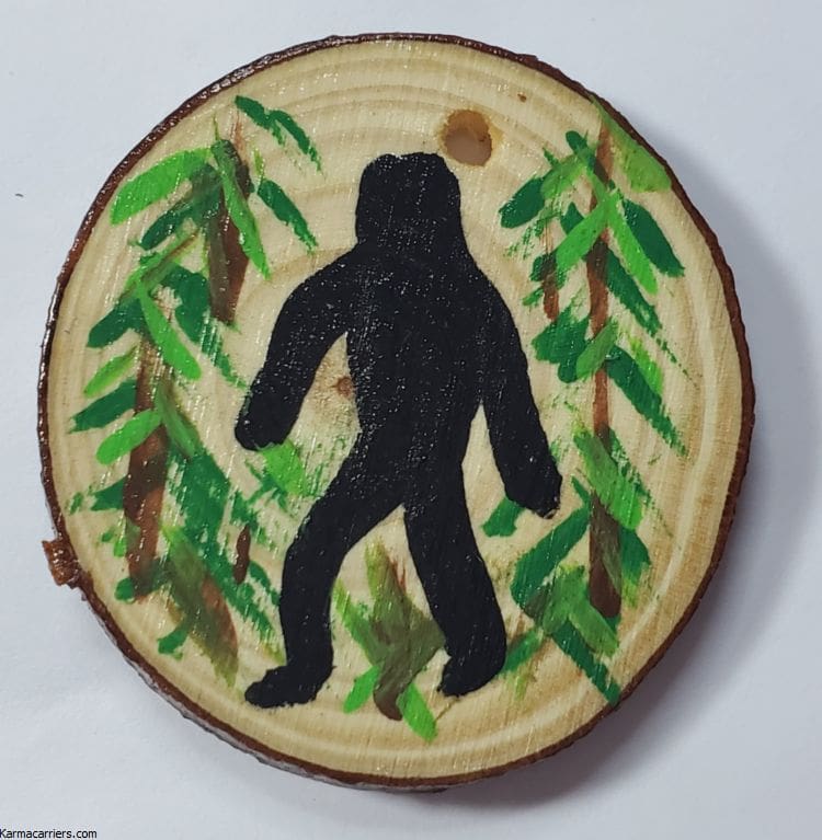 A painting of a bigfoot on wood slice.