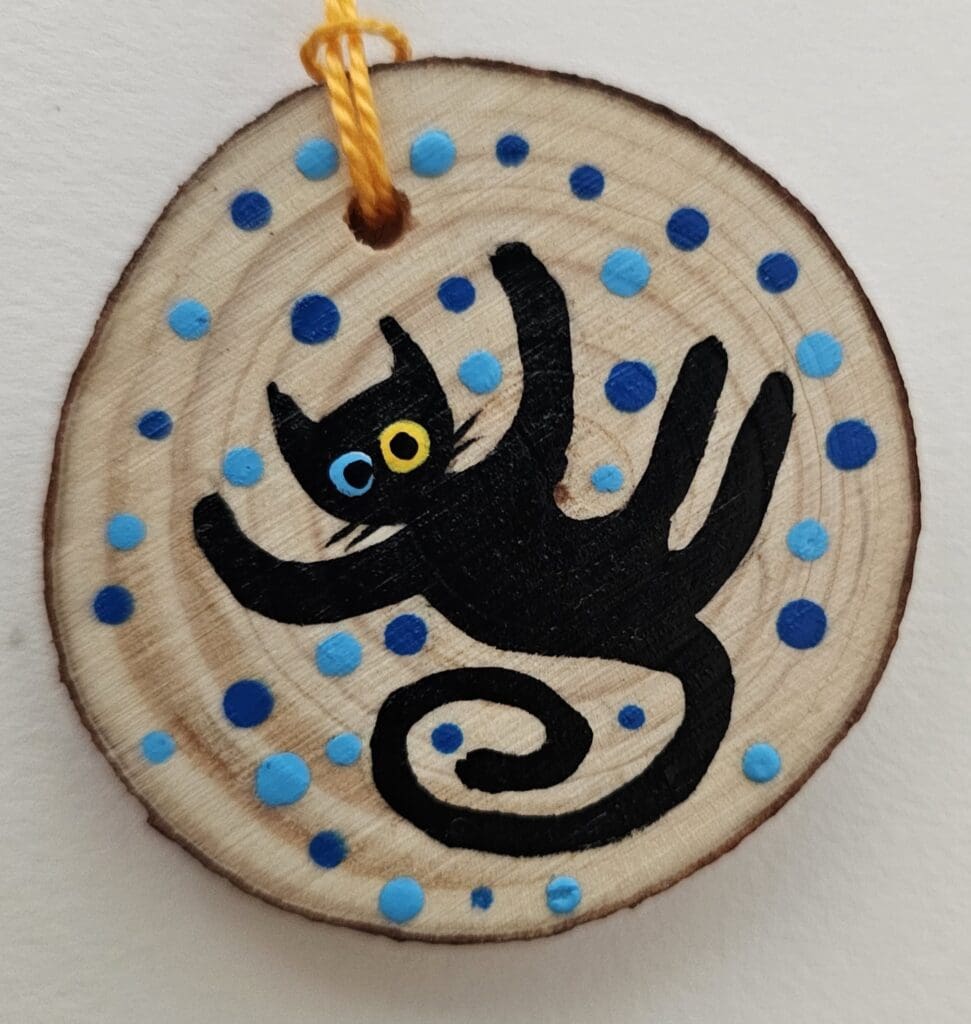 A cat ornament with blue dots on it.