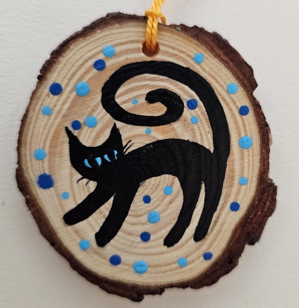 A cat ornament with blue dots on it.