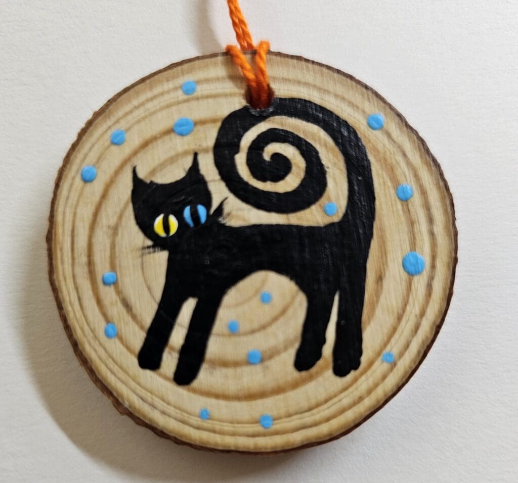 A cat ornament with blue dots on it.