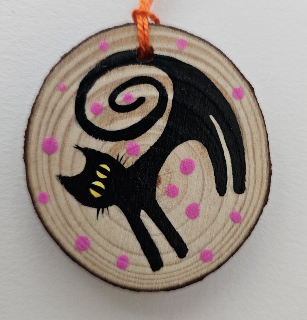 A cat ornament hanging on the wall.