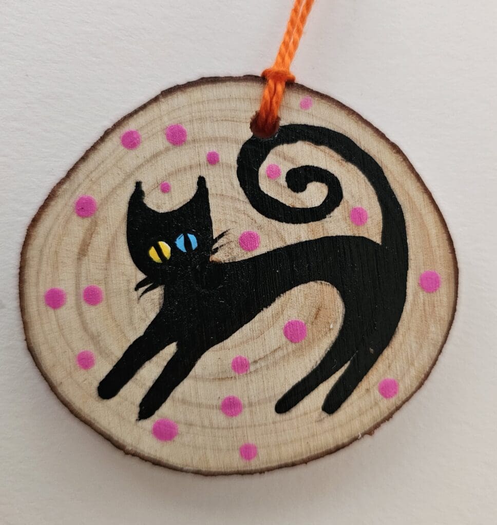 A black cat ornament hanging on a string.