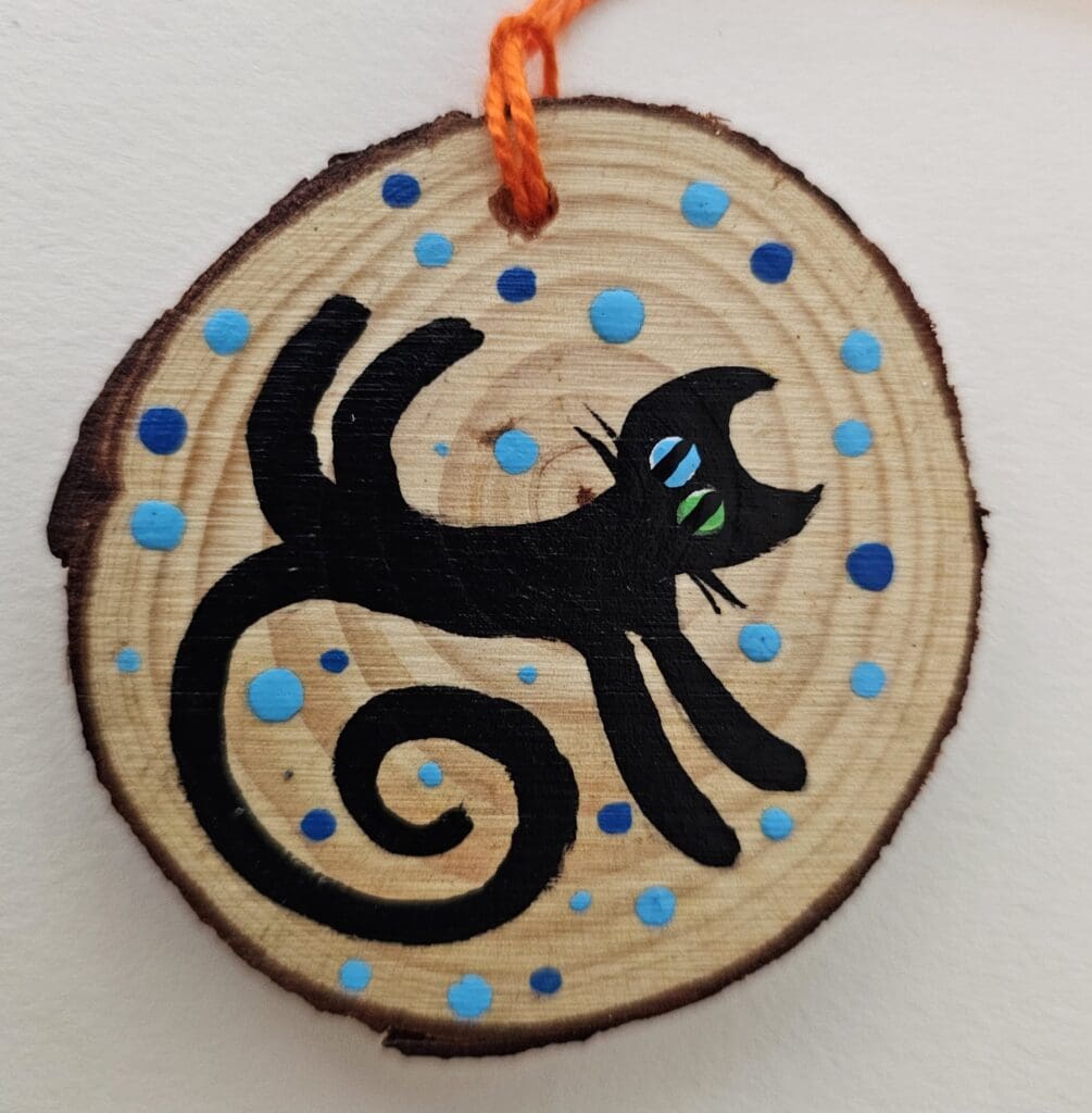 A black cat ornament hanging on a string.