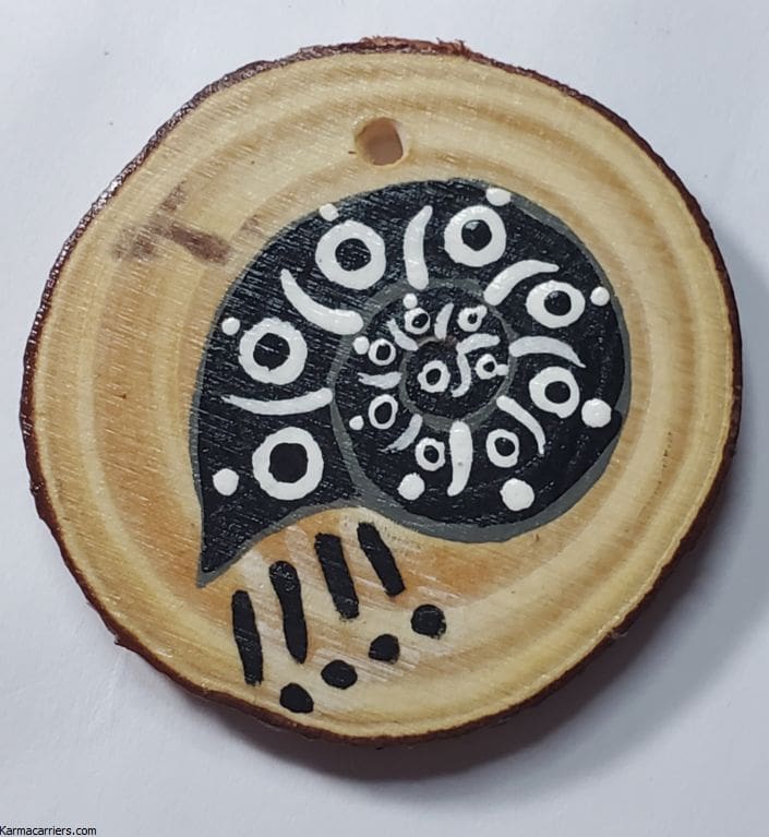 A wooden disc with black and white designs on it.