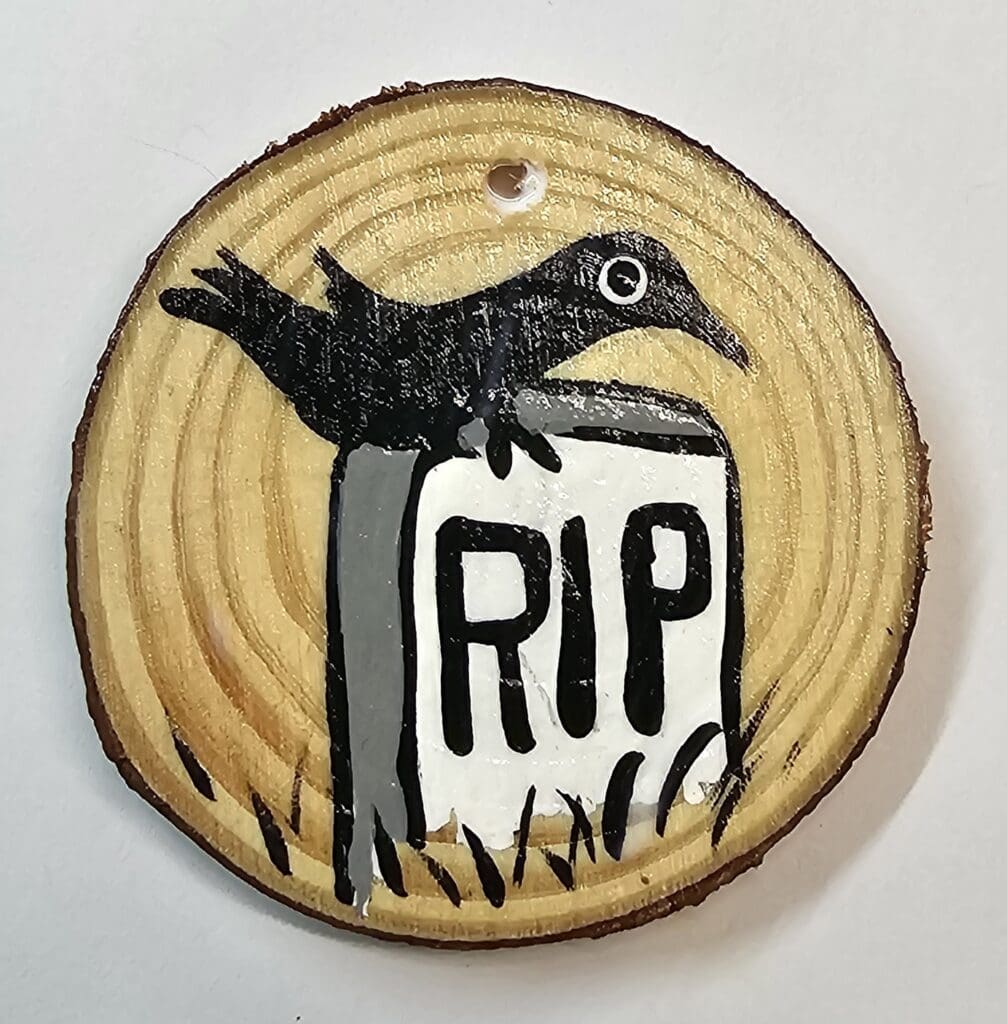 A wooden disc with a bird on top of it.