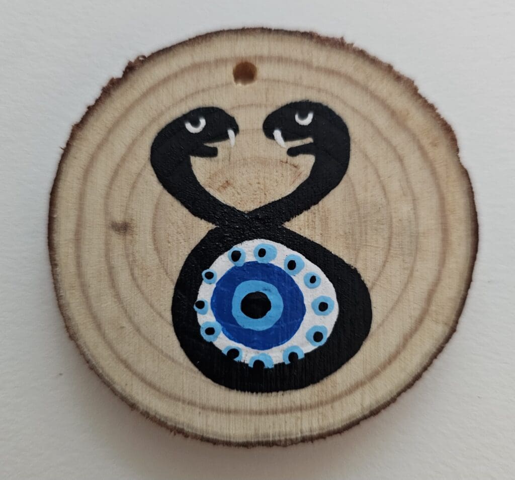 A wooden disc with an evil eye painted on it.