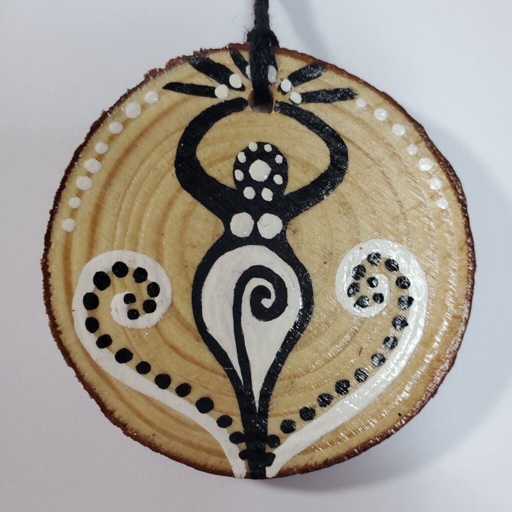 A wooden disc with black and white designs on it.