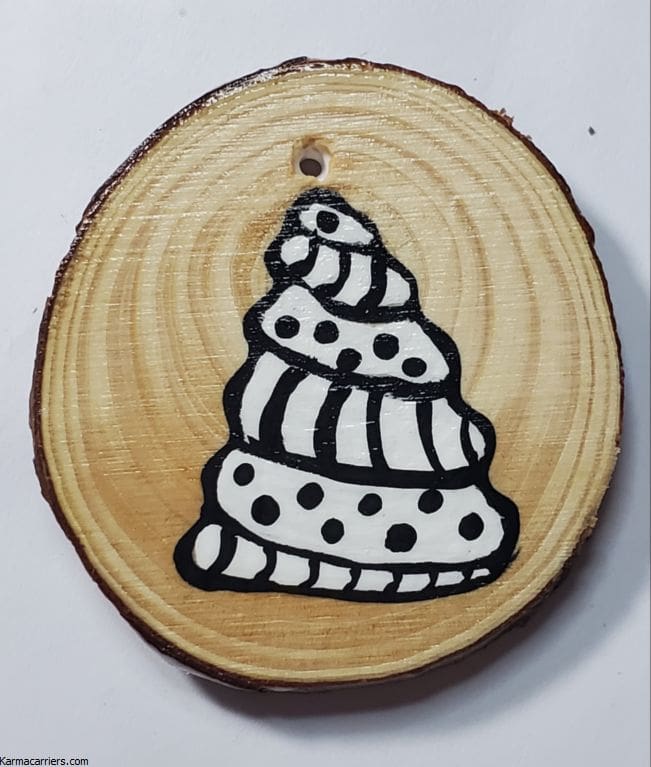 A wooden slice with a drawing of a tree