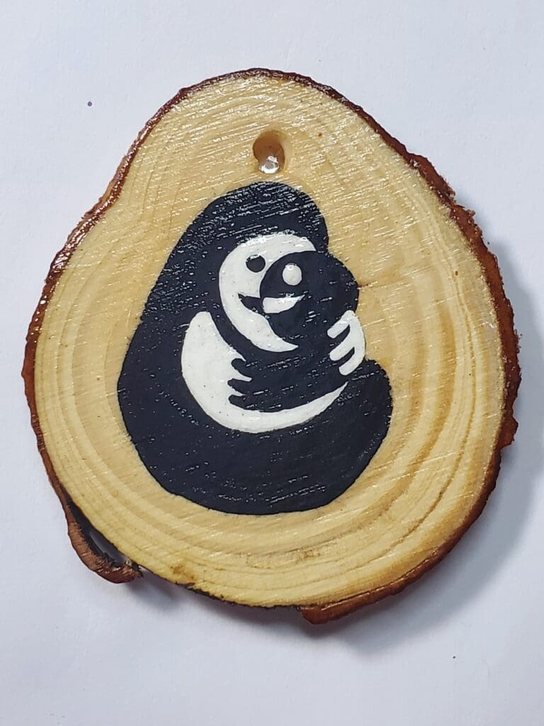 A wooden slice with a picture of a gorilla on it.