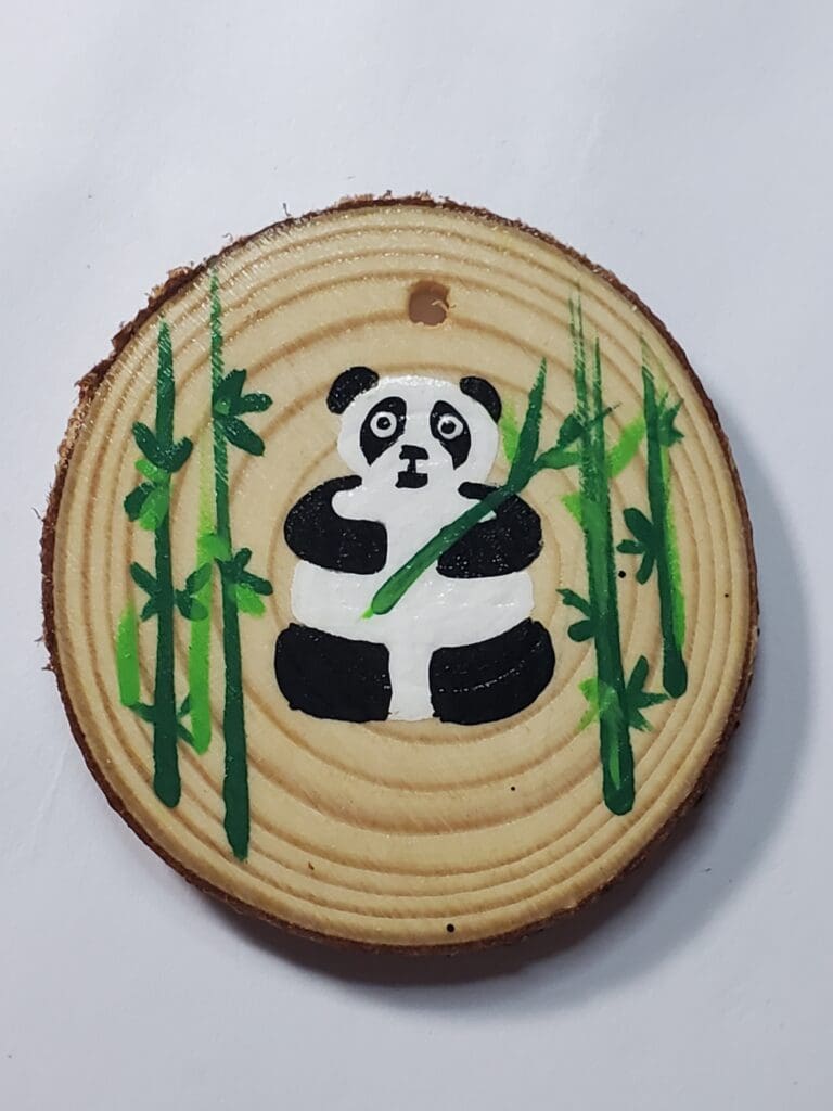 A panda bear sitting on top of a tree stump.