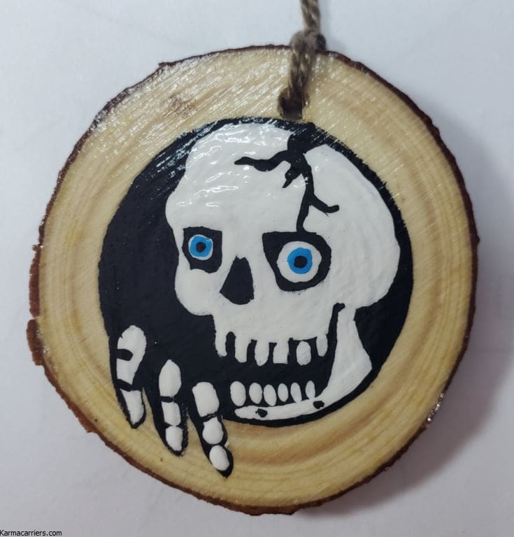 A wooden disc with a skull painted on it.