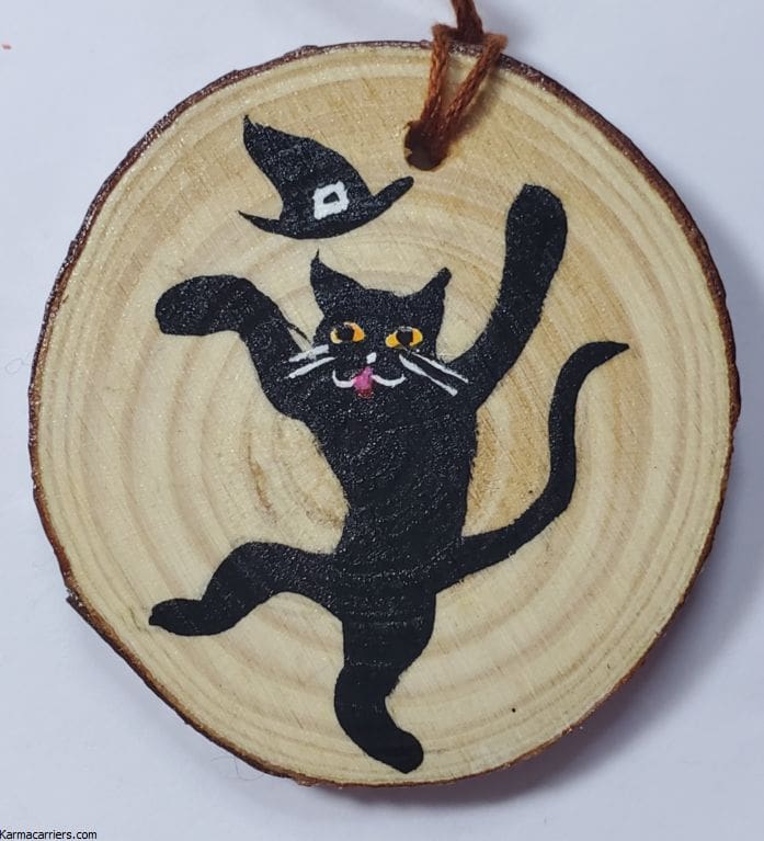 A black cat with a witch hat on it's head.