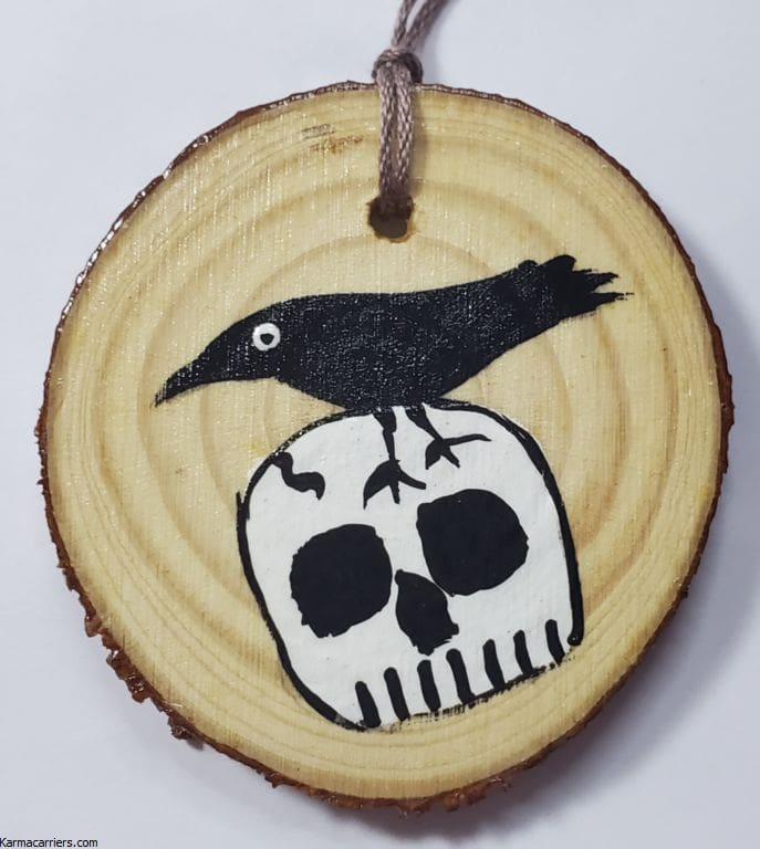 A wooden disc with a black bird on top of it.