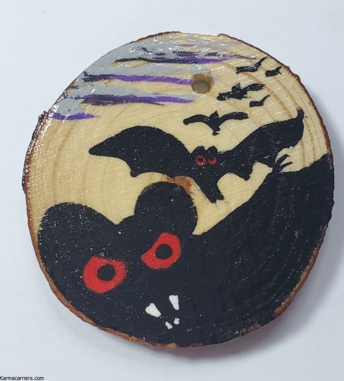 A wooden disc with bats and a bat flying in the background.