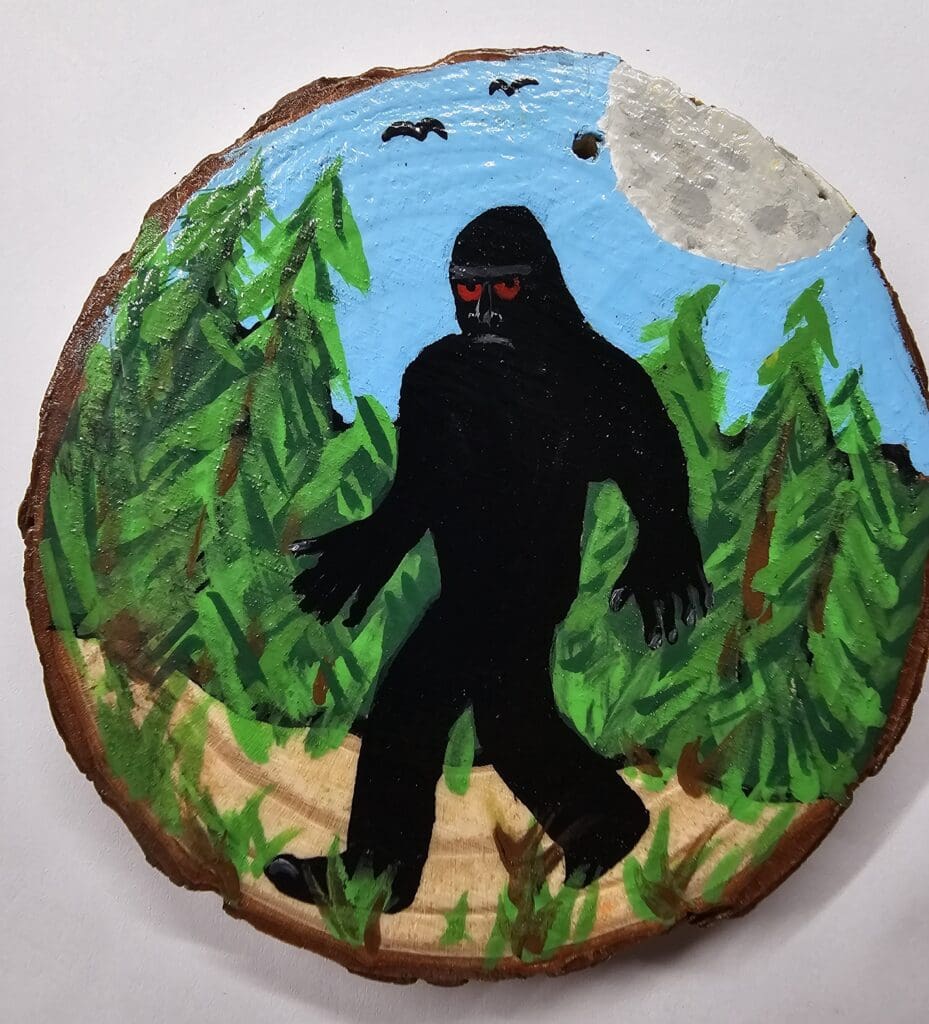 A painting of a gorilla on a tree stump.