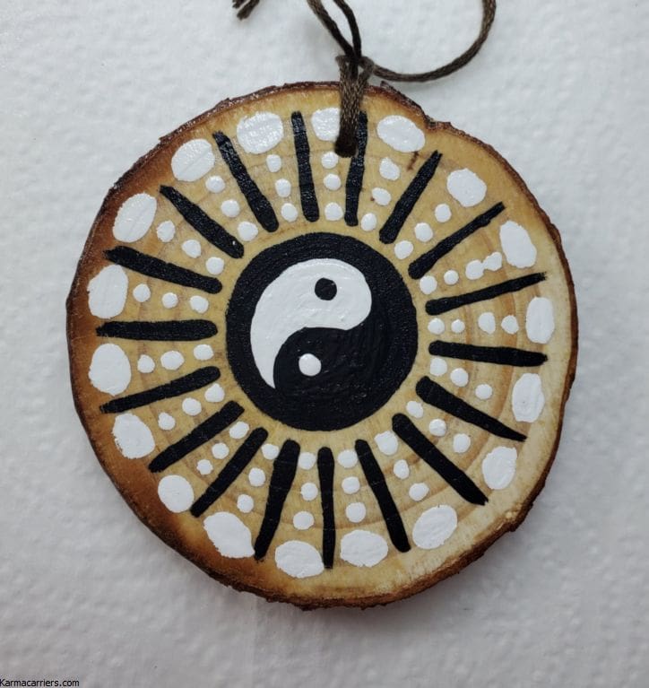 A wooden disc with an image of a yin yang on it.