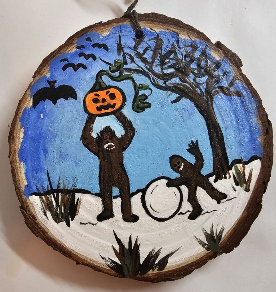 A painting of two bears and a pumpkin on a tree.