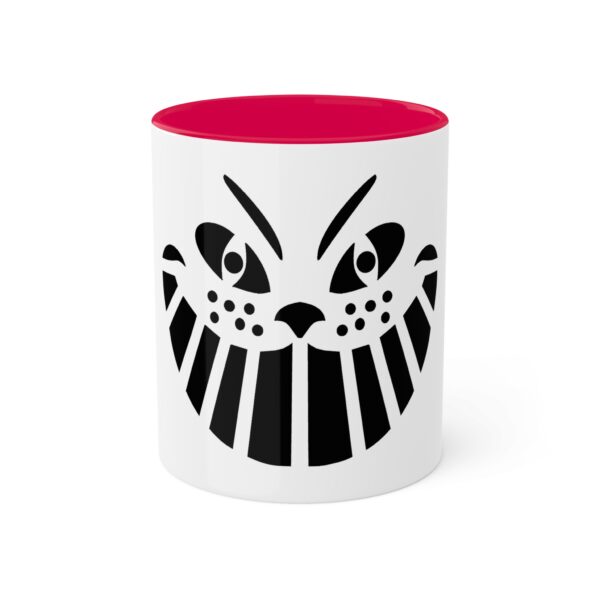 A red and white mug with an image of a cat 's face.