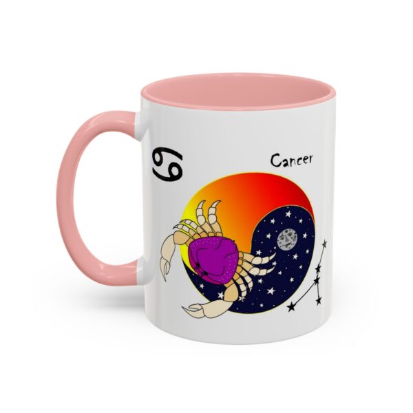 A pink and white coffee mug with the zodiac sign cancer on it.