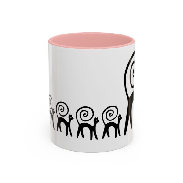 A pink and white mug with a design of black animals.