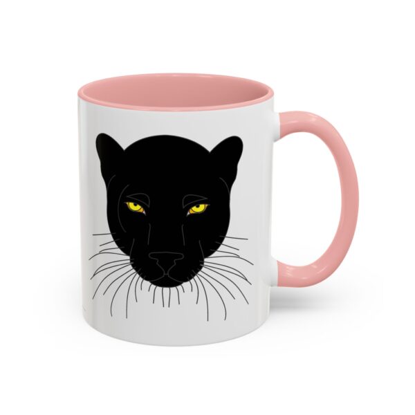 A pink and white mug with a black cat face on it