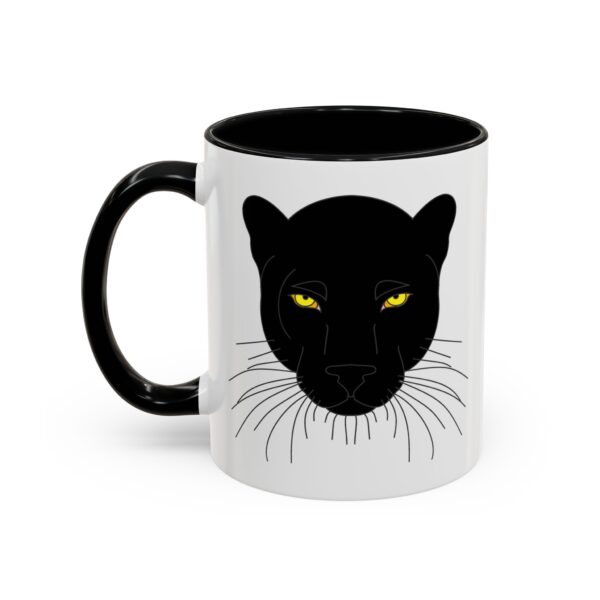 A black and white mug with a cat 's face.