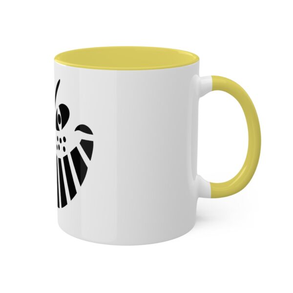 A yellow and white coffee mug with the shield of hawkman