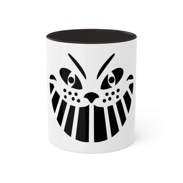 A black and white mug with an image of a cat 's face.