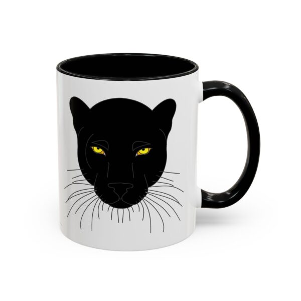 A black and white mug with a cat 's face on it.