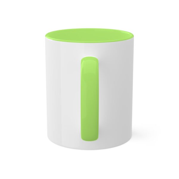 A white and green coffee mug sitting on top of a table.