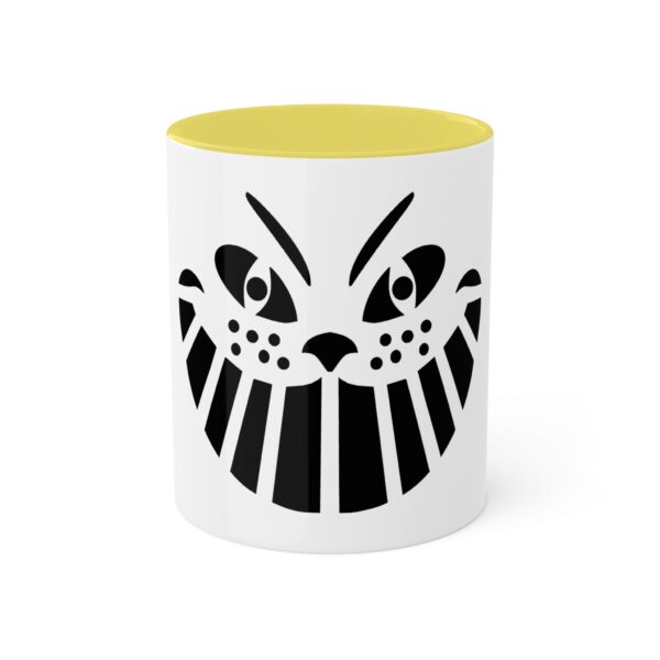 A yellow and white mug with an image of a cat 's face.