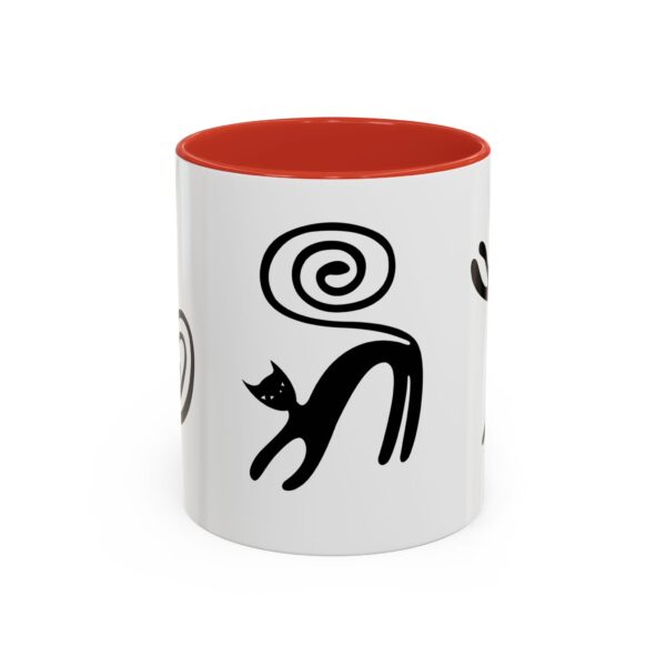 A red and white mug with black cats on it