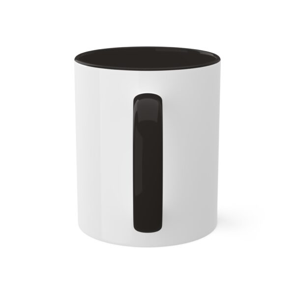 A white and black mug with the handle up.