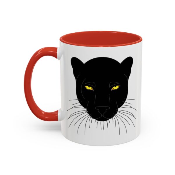 A red and white mug with a black cat face