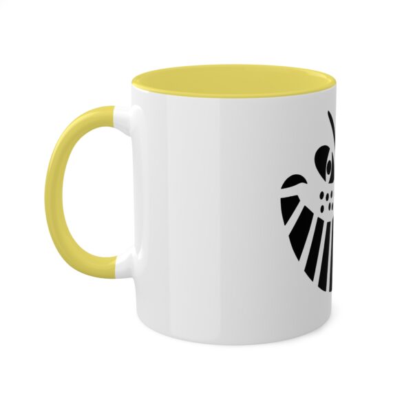 A yellow and white mug with a black design on it.