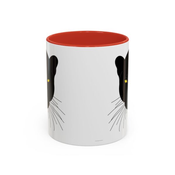 A red and white mug with a black cat on it