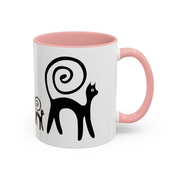 A pink and white mug with an image of two cats