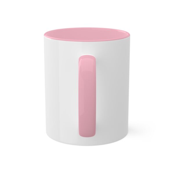 A pink and white coffee mug on top of a table.