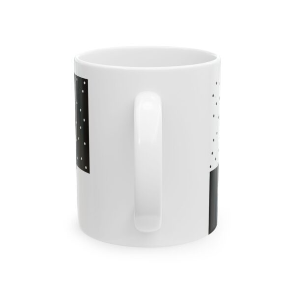 A white mug with a black and white design on it.