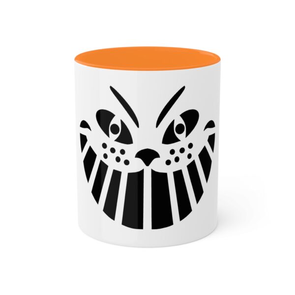 A white and orange mug with an image of a cat 's face.