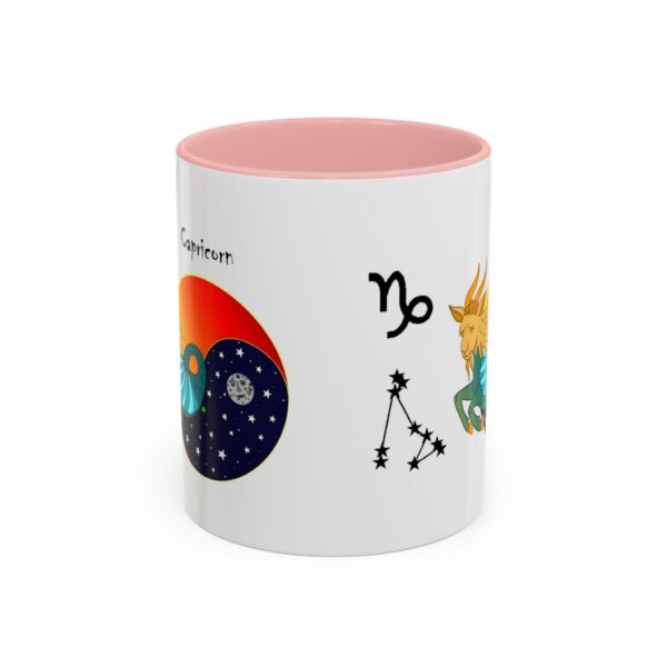 A pink and white mug with various astrological symbols.