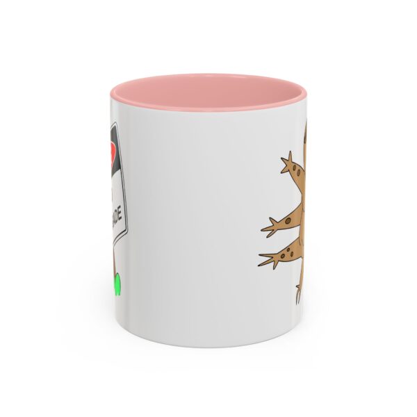 A pink and white coffee mug with a picture of a lizard.