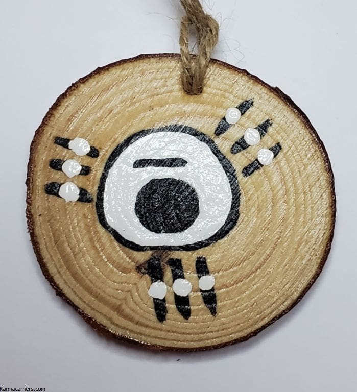 A wooden disc with an animal design on it.