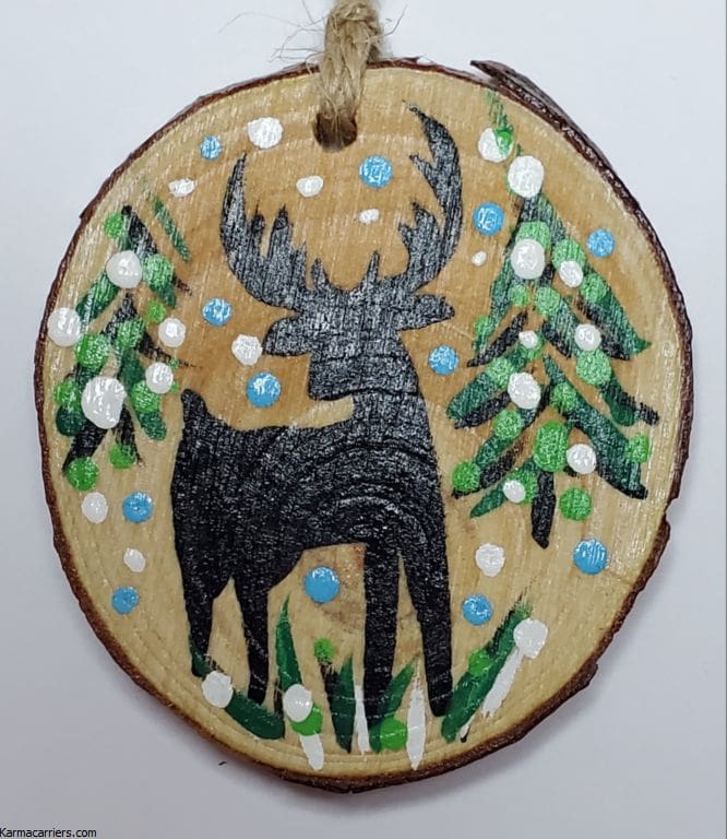 A painting of a deer on wood slice