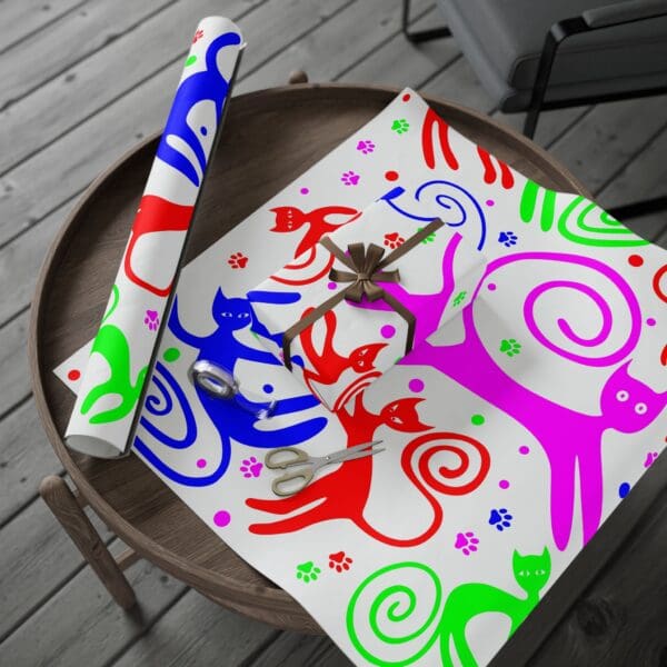 A table with a cat wrapping paper and a gift bag.