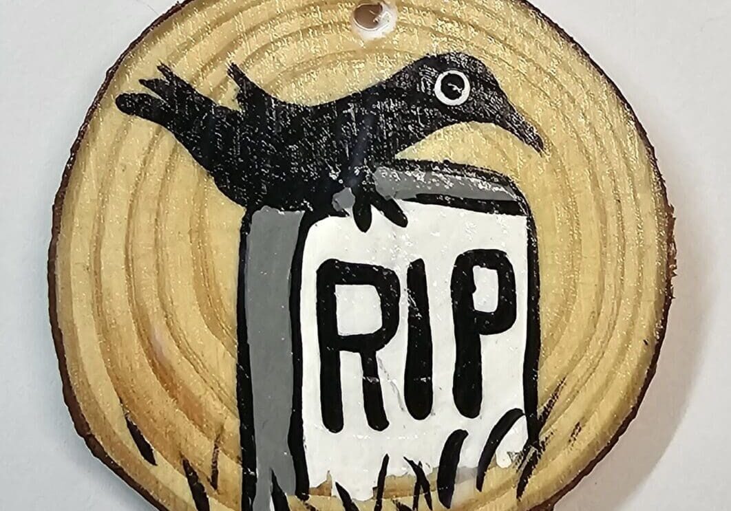 A wooden disc with a bird on top of it.